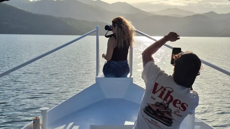 A couple taking photos from the bow