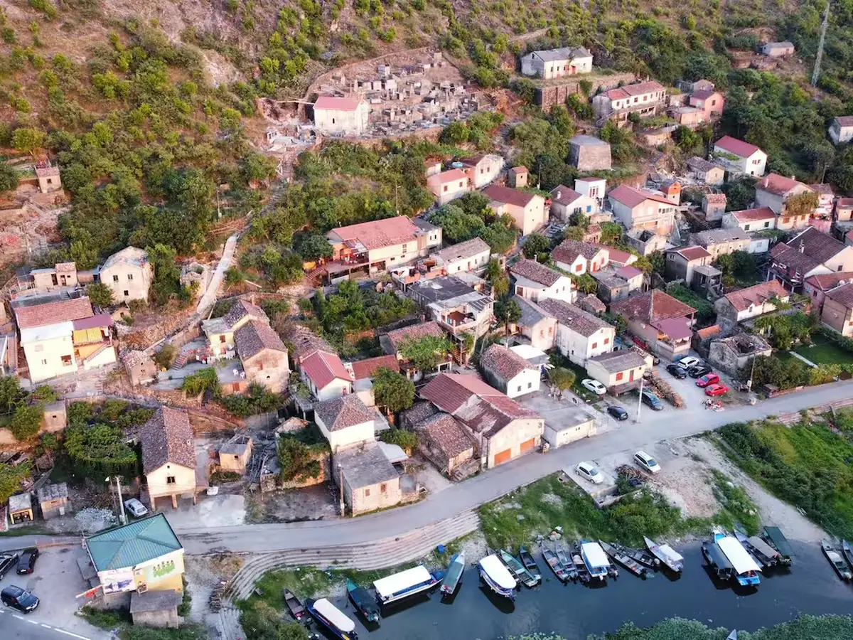 Aerial view of Vranjina village beneath its hill, surrounded by Skadar Lake